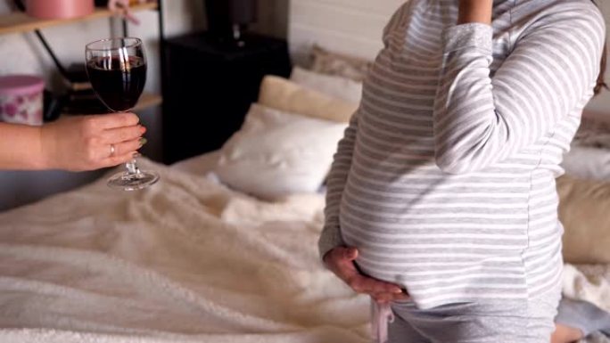 孕妇在床上的卧室里拒绝喝酒。