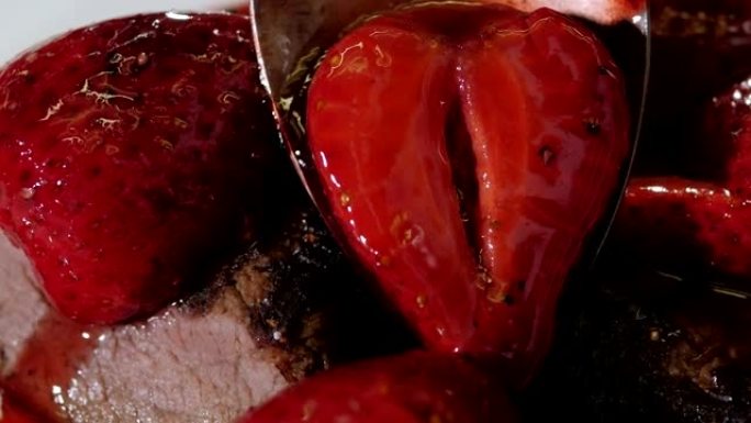 大厨将辣酱和草莓倒在牛排上的特写镜头。