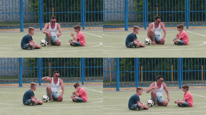 足球教练在夏季城市营地的操场上积极与男孩交谈。