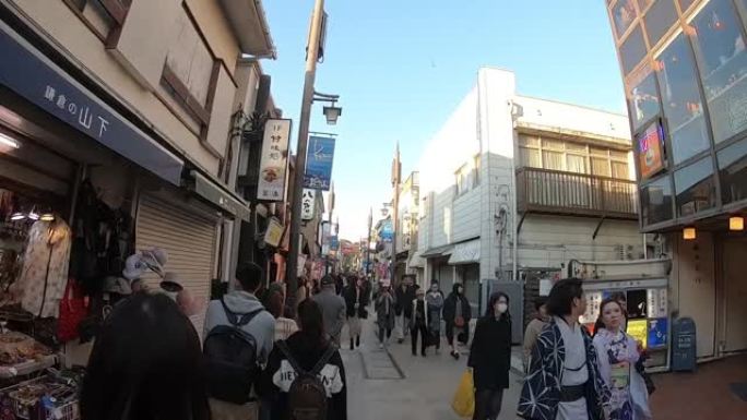 游客在镰仓市的小町商店街旅行。