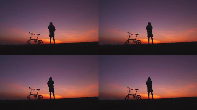 人与自行车在日落晚霞黄昏夕阳落日火烧云
