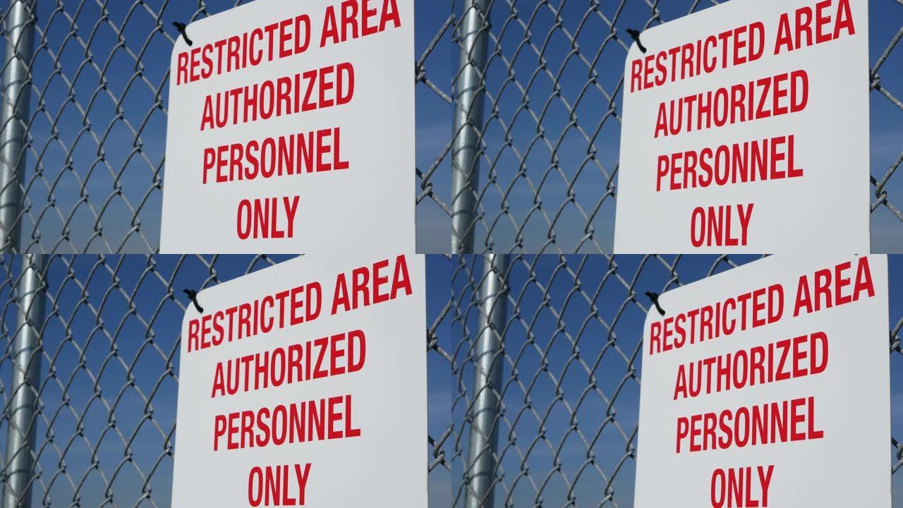 限制区域，授权人员在美国签字。红色字母，金属围栏上的远离警告，美国边境标志。没有侵入通知意味着违规者