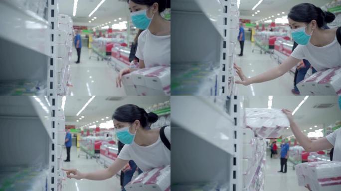 年轻的亚洲女性戴着口罩在新型冠状病毒肺炎危机期间在杂货店选择手巾纸巾，库存供应，电晕病毒大流行传播预