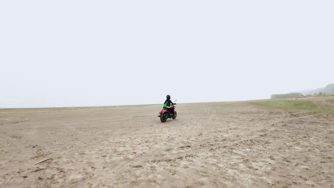 女摩托车骑手在空旷的沙漠中骑行飙车