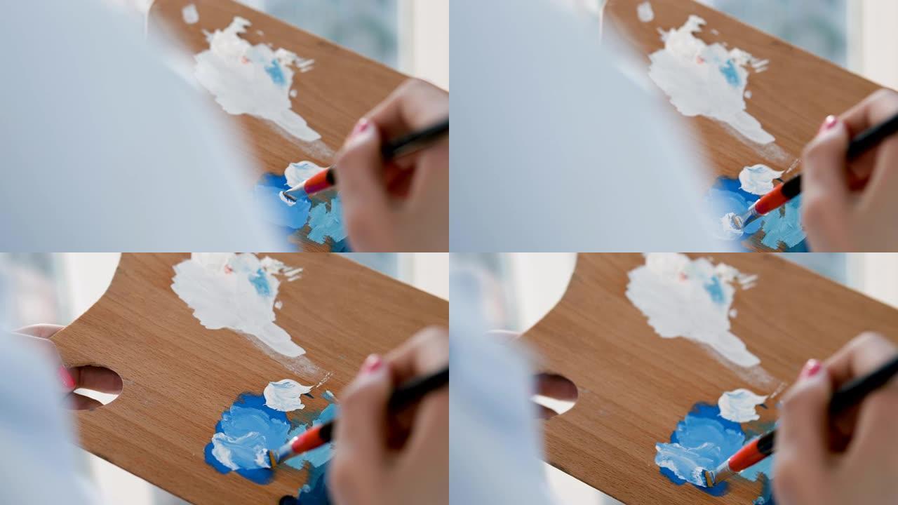 设计师手握画笔，在调色板上混合颜色，从事艺术项目
