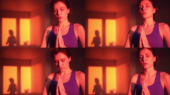 一个平静的年轻女子在日落时在客厅里冥想。瑜伽和禅宗概念，呼吸练习健康的生活方式