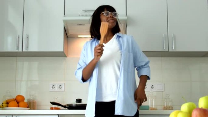 有趣的美国黑人妇女试图像机器人在厨房做饭一样跳舞