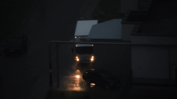 这辆车停在倾盆大雨中，大灯和应急灯亮起