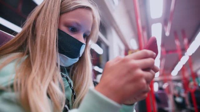 戴着口罩的少年在subway的智能手机上计划他的日常工作。