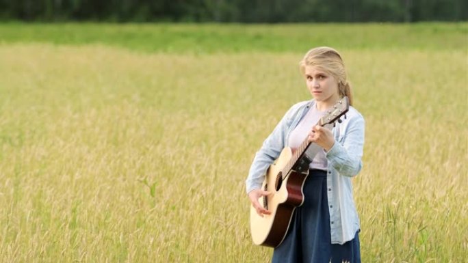 夏夜日落时，年轻女子在麦田上唱歌弹吉他