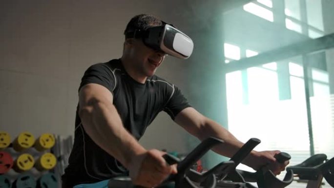 一名男子戴着VR头盔在自行车模拟器上进行繁重的运动