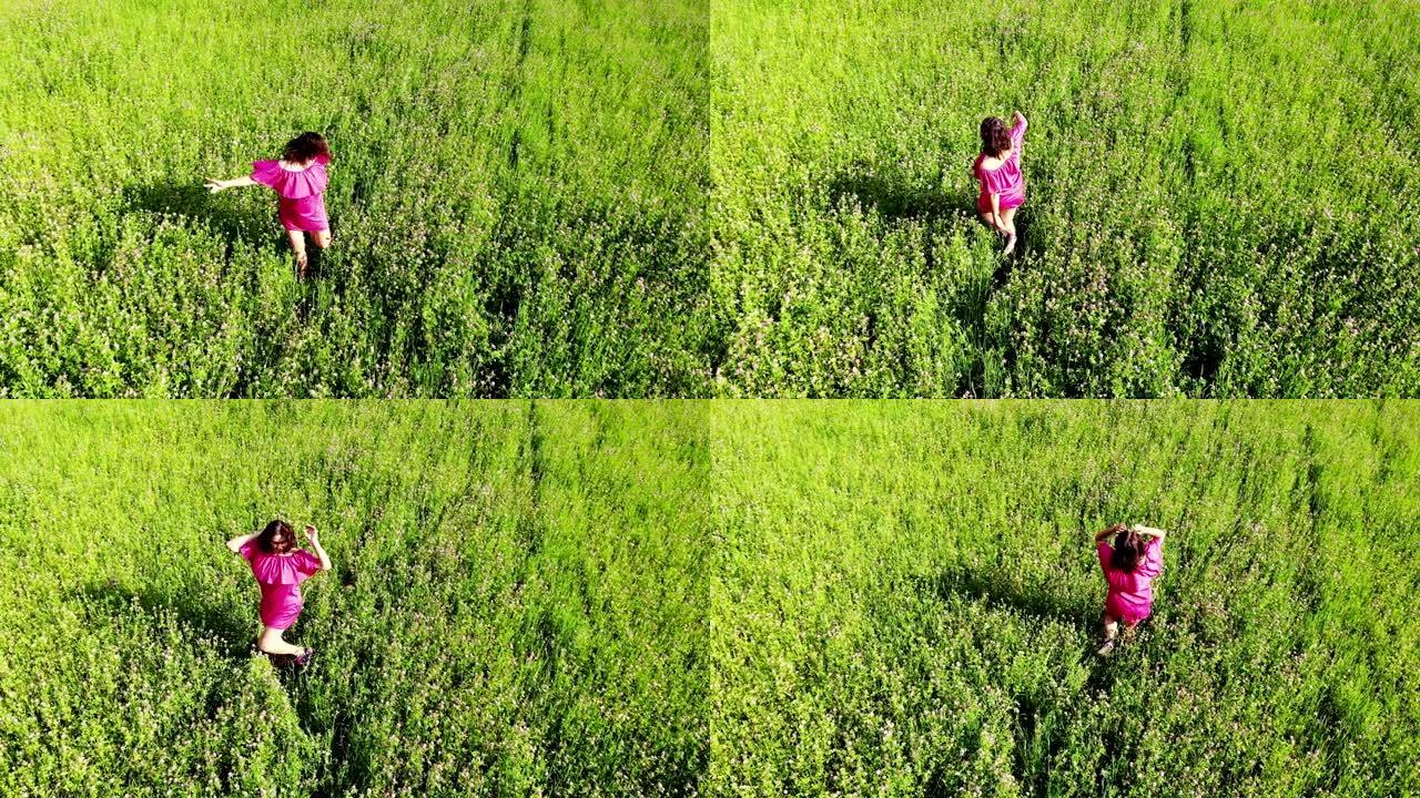 性感的女孩穿着红色连衣裙在户外绿色的田野旋转，触摸头发和移动诱人，有趣，快乐，享受，自由概念，从无人