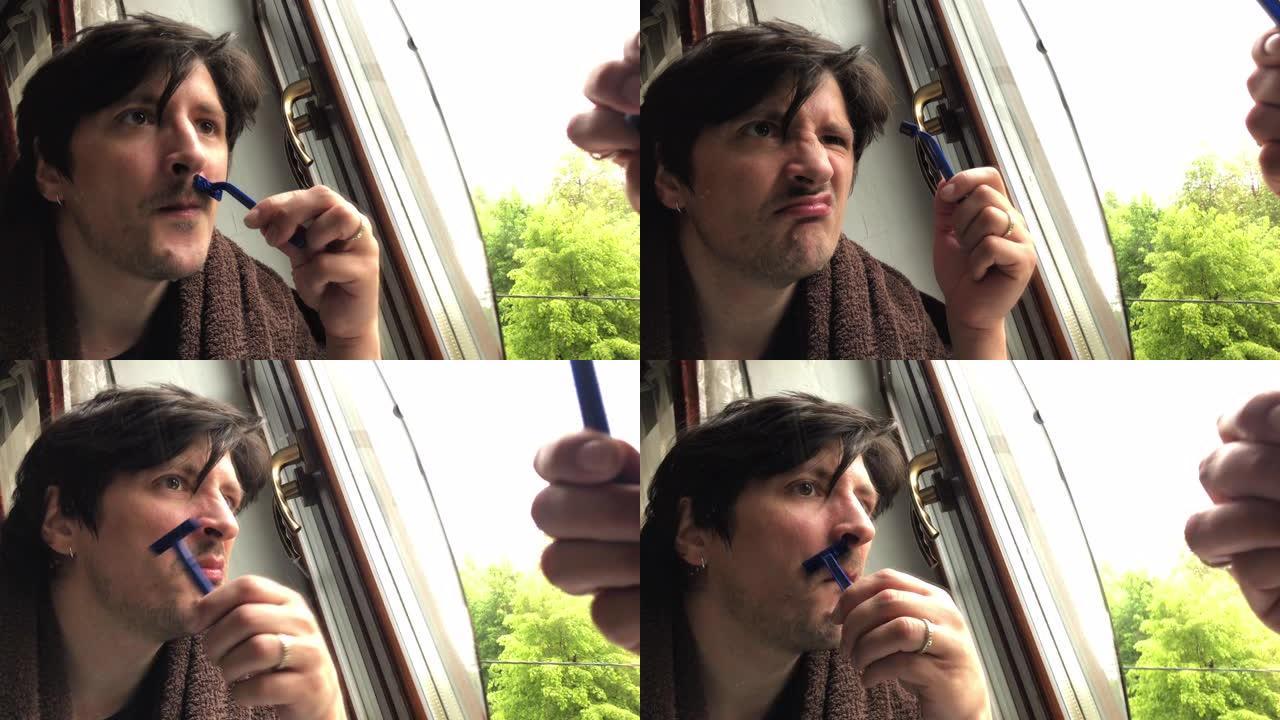 男人在家里窗户附近刮胡子