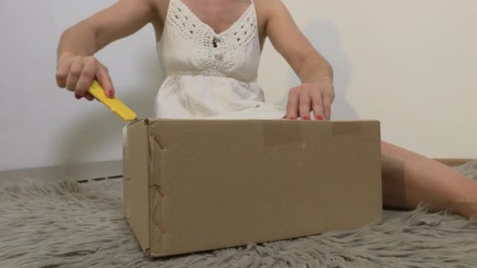 女人用刀打开纸箱
