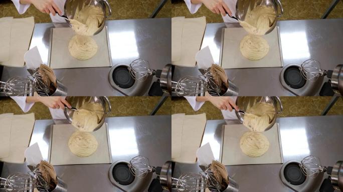 女厨师将液体蛋糕或馅饼面糊倒入烤盘的特写镜头。