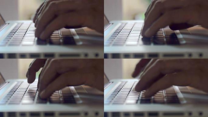4kclose up Man hands在家里工作的笔记本电脑键盘上打字。手触摸打字键盘使用inte