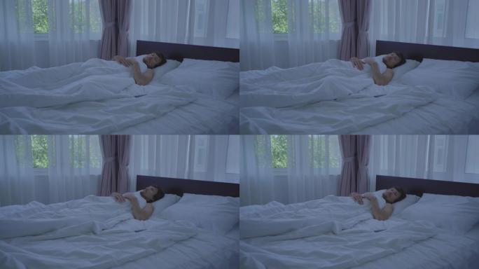 躺在床上的男人睡不着。失眠概念