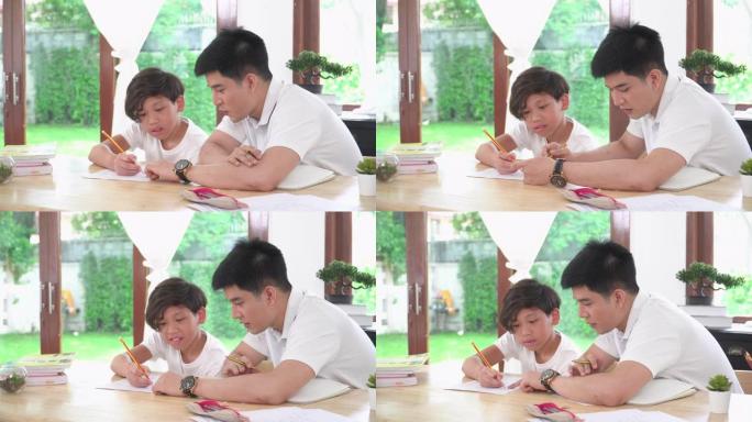 在家上学的概念是一个孩子的亚洲家庭的新常态。年轻的单身父亲作为兄弟，家教，教数学问题，并在纸上给男孩