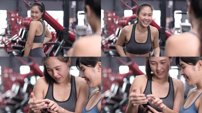 运动年轻的亚洲女性和朋友用手机给她的朋友拍照，女性在健身房玩得开心，运动健身训练锻炼和健康的生活方式