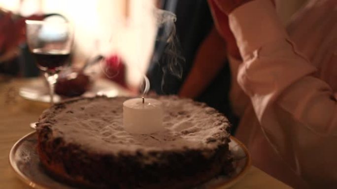 老人庆祝70岁生日，老人吹生日蜡烛蛋糕