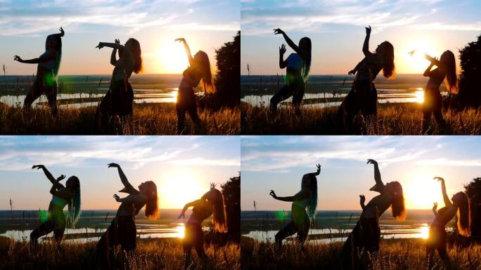 大自然中的有氧运动 -- 三个年轻女子在日落时跳舞