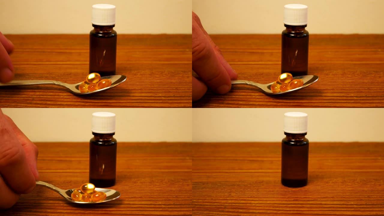 儿童和成人用液体维生素d瓶。维生素D3滴。鱼油Omega-3胶囊在桌子上的勺子中补充透明的黄色球。玻