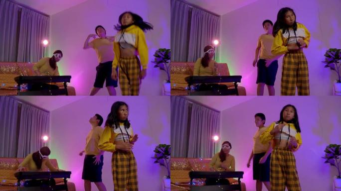 快乐的亚洲妈妈和两个孩子在客厅用led灯一起跳舞，生活方式理念。