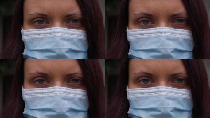 一个有着蓝眼睛和医用口罩的女人的特写脸。