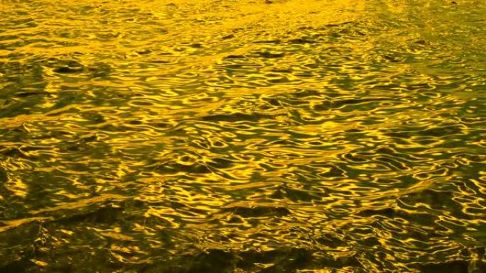 阳光照射在金色的水面上。太阳在水面闪烁的自然背景。永远不会看到无尽的海水表面和阳光。海水表面的纹理太