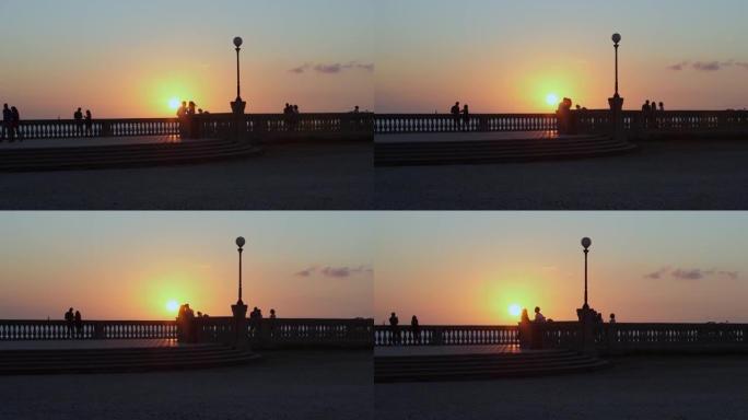 日落时分，情侣在海边的露台上跳舞，慢动作视频。