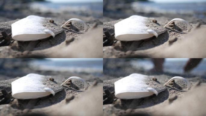 废弃的covid安全面罩躺在沙丘下的海滩上，在公共区域2020年2020年7月19日中冠状病毒概念镜
