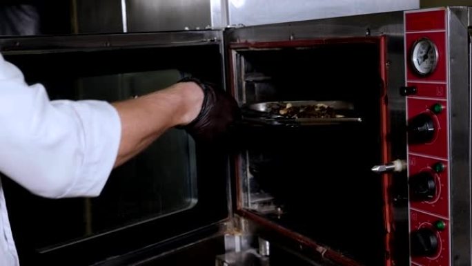 厨师从烤箱里拿出烤牛肉牛排的特写镜头。慢动作。