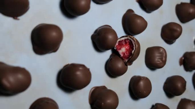 新鲜红色和闪亮的新鲜覆盆子蘸自制黑白巧克力的慢动作视频