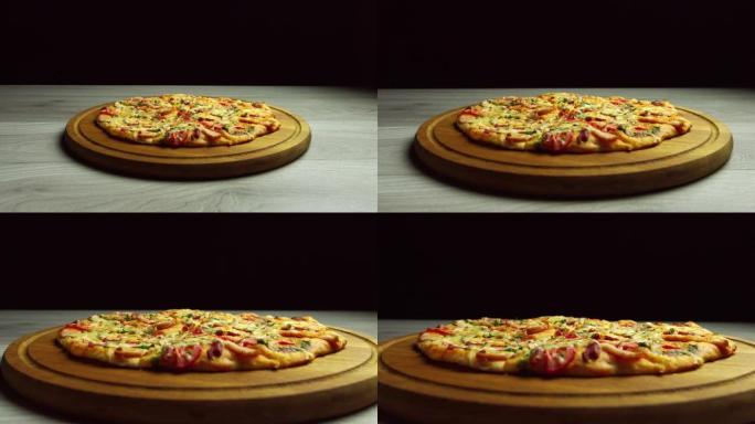 意大利辣香肠比萨饼和奶酪放在木板上。黑暗背景。披萨的平稳运行
