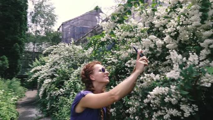 智能手机。一个年轻的女人在智能手机上拿花。