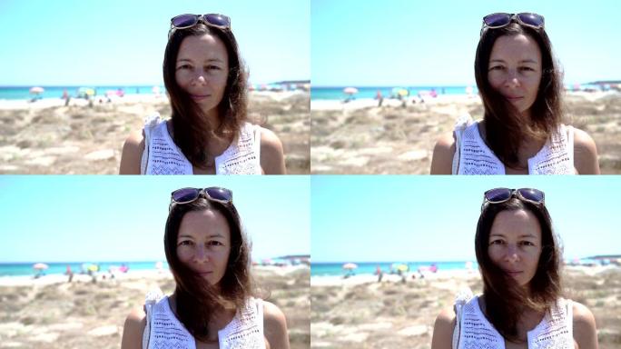 美丽微笑自信的高加索女人漂亮的脸蛋，表情积极，看着相机独自在海滩上摆姿势 -- 夏季旅行和度假概念