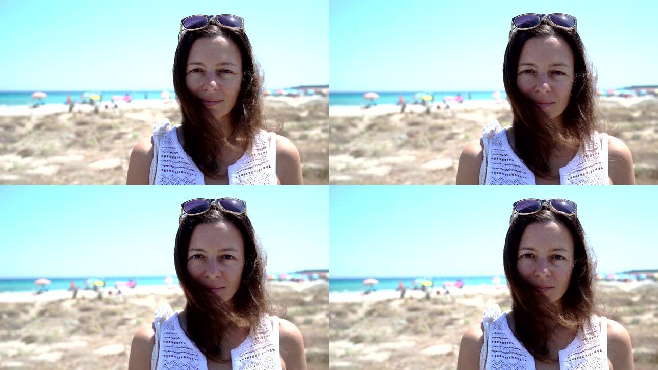 美丽微笑自信的高加索女人漂亮的脸蛋，表情积极，看着相机独自在海滩上摆姿势 -- 夏季旅行和度假概念