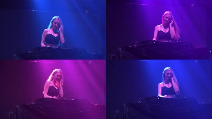 性感的女孩DJ在俱乐部的灯光和声音的音乐会上播放转盘电子舞曲和舞蹈。带有背景动画的抽象电子特效屏墙。