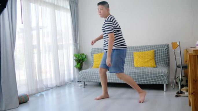 快乐的亚洲青春期男孩在家练习舞蹈，生活方式理念。