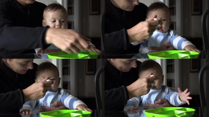 母亲喂养婴儿蹒跚学步的婴儿餐休闲而坦率