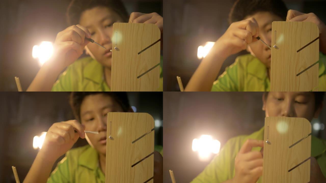 快乐的亚洲男孩和女孩在晚上在家，生活方式和DIY概念中自己拧木架子。
