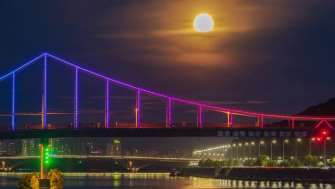 在满月升起的背景下，第聂伯河上人行天桥上的人们的剪影
