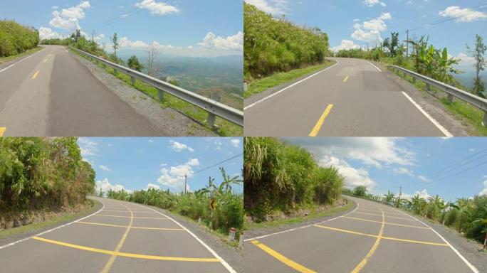 一个人在山上的路上骑摩托车的视点镜头。公路旅行概念
