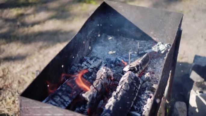 烧煤在烤架上的火上。特写。火和烟。在火刑柱上做饭。