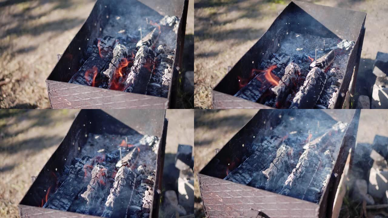 烧煤在烤架上的火上。特写。火和烟。在火刑柱上做饭。