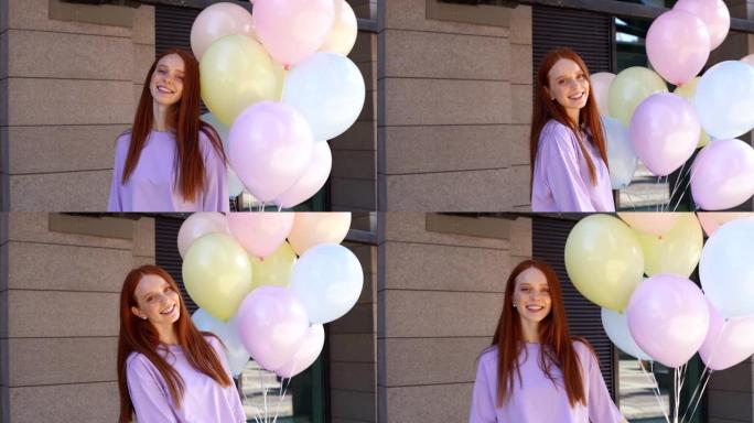 迷人的女孩的肖像，红头发看着相机，拿着巨大的气球喷泉。