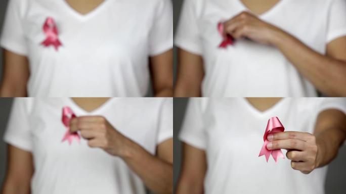 女人展示她的粉红色乳腺癌意识丝带