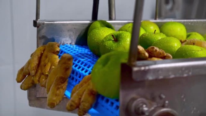 姜和苹果在传送带上，自动化挤压有机果汁。