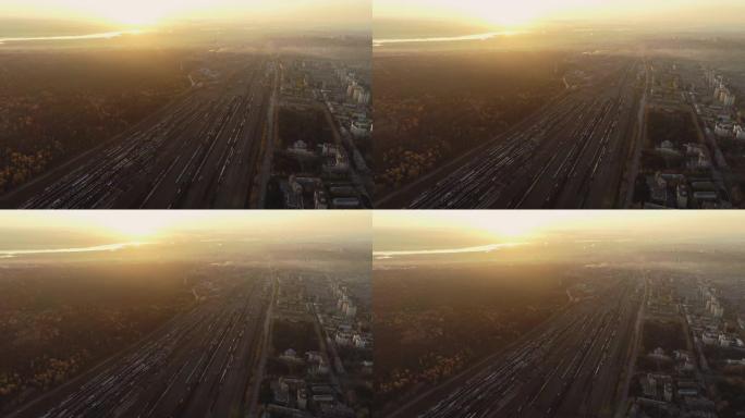 一架无人机在火车站上空起飞。空中俯视图。日落时的铁路分拣站。货站的许多货车。调车场大型交通枢纽全景。