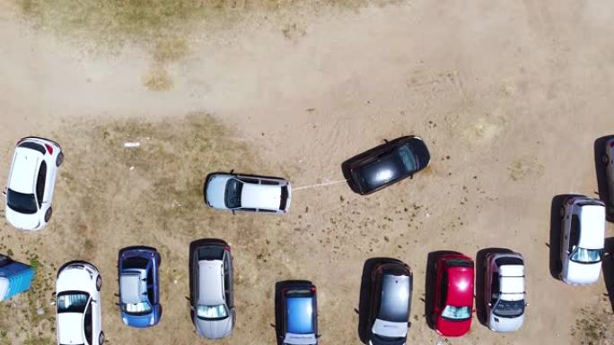 汽车用电缆从沙子上拉另一辆汽车。汽车卡在沙子里，另一辆车试图拉它。